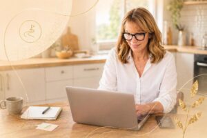Woman sitting in her kitchen dining area online on her laptop